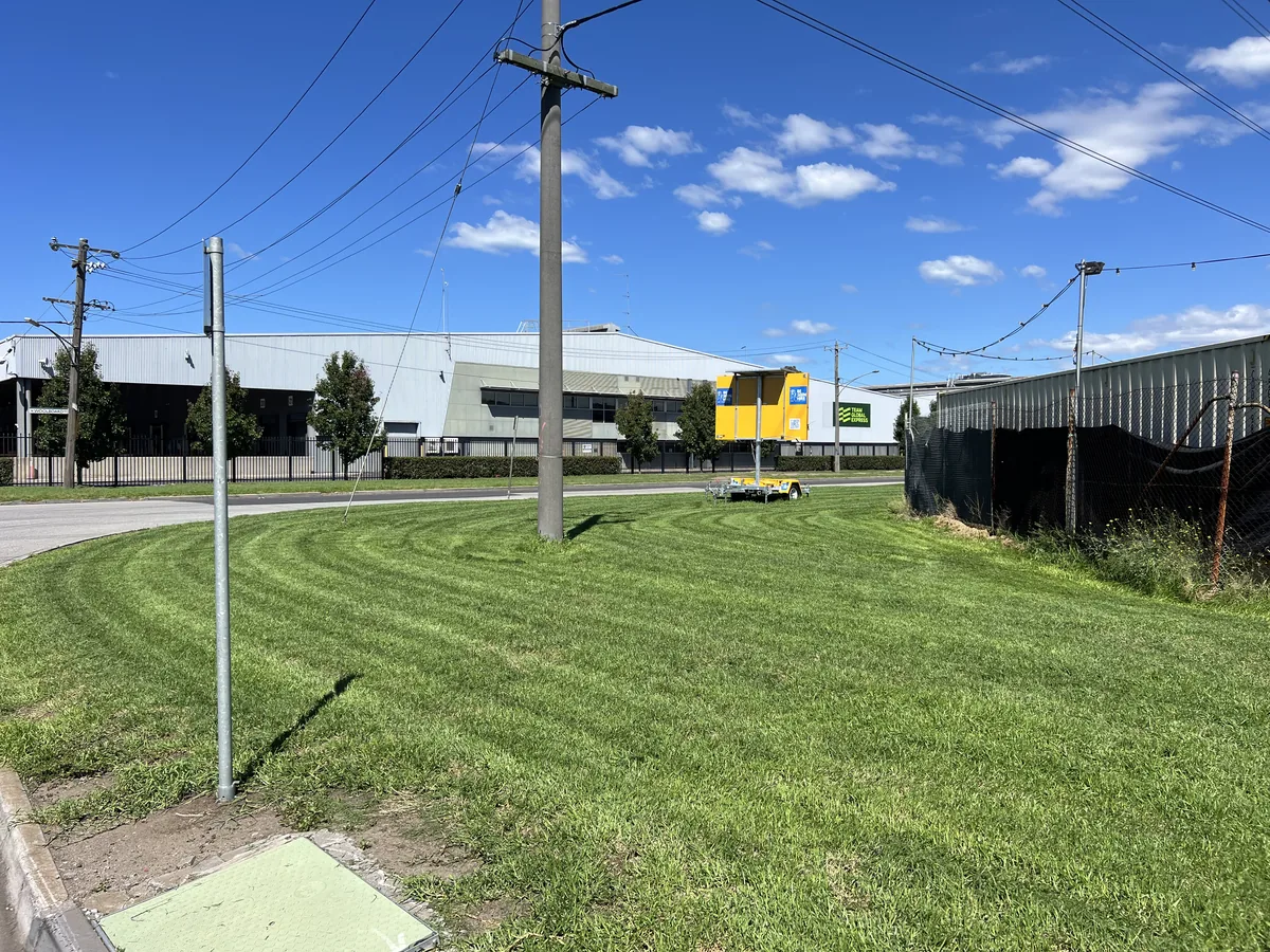 Fresh ride-on mowing stripes across a large open lawn
