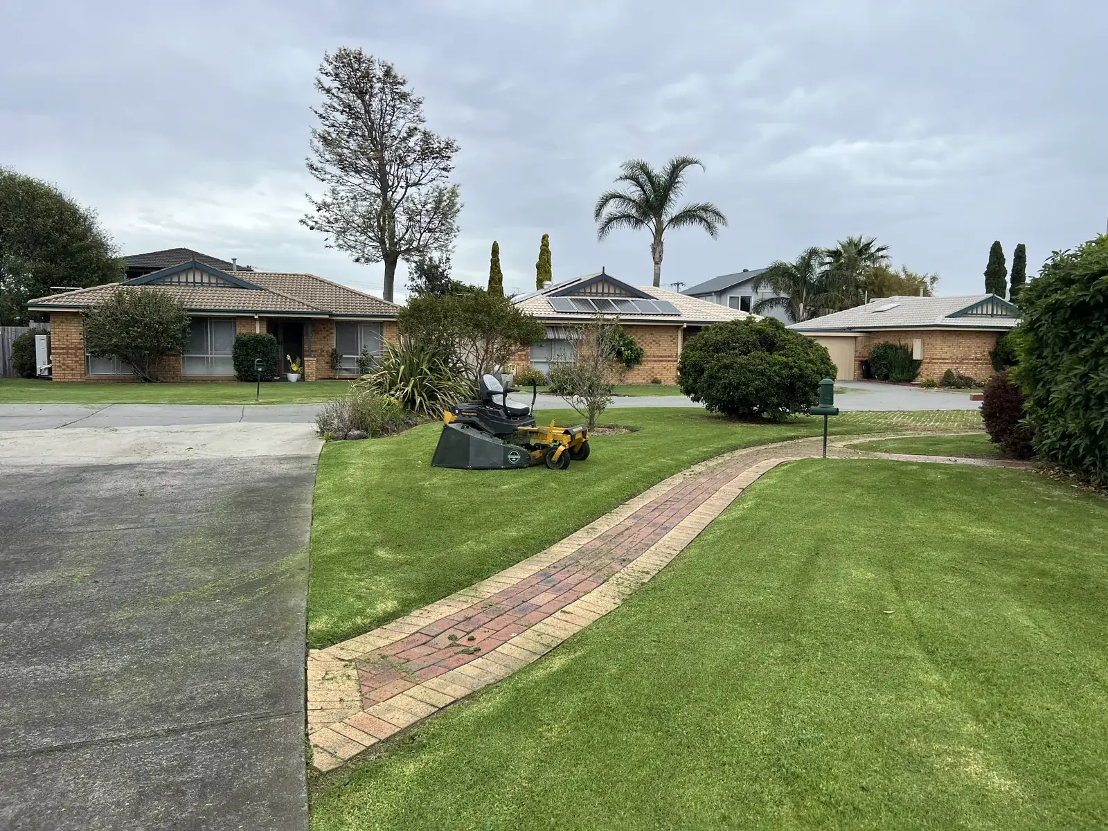 Ride-on mower on freshly striped body corporate lawns in south-east Melbourne